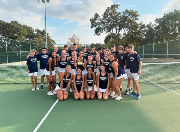 Champion High School Tennis JV players, including Boone Sills and Sofi Rubio hold their District Championship trophy at the District Tournament.
